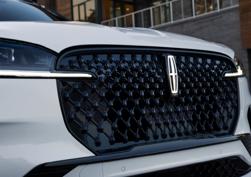 The black grille of a white 2025 Lincoln Aviator® SUV is shown with its fog lights on. | Doral Lincoln in Doral FL