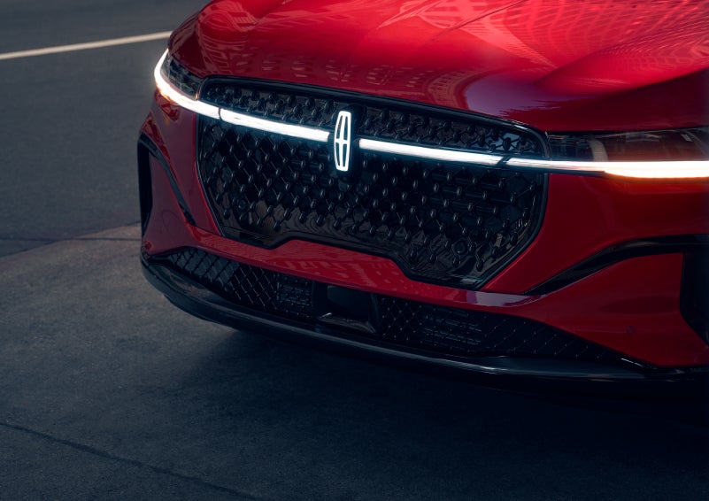 The available front LED light bar and center Lincoln Star logo glow at dusk. | Doral Lincoln in Doral FL