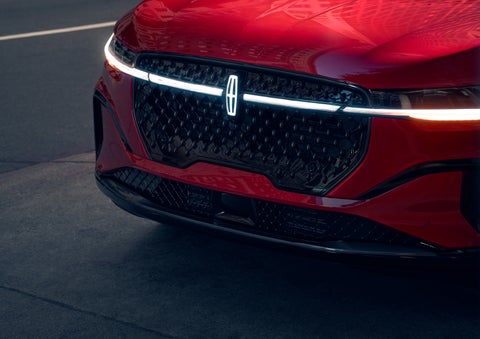 The available front LED light bar and center Lincoln Star logo glow at dusk. | Doral Lincoln in Doral FL